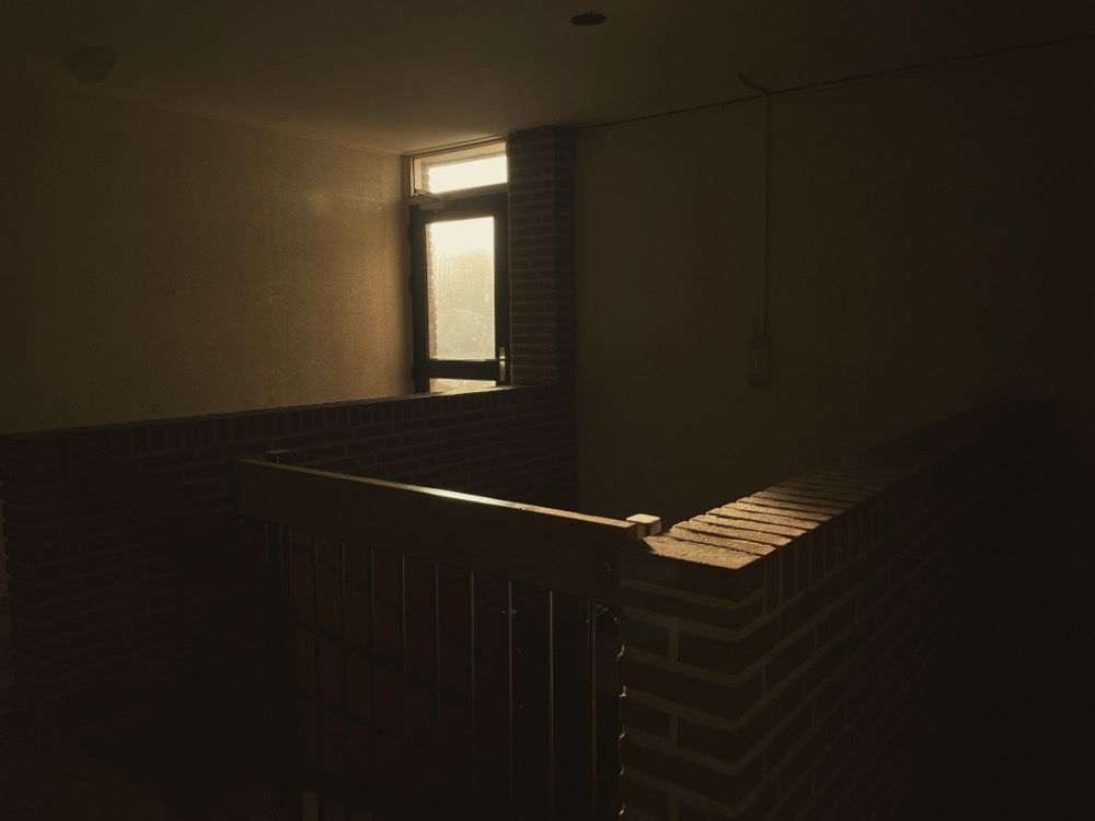 An apartment complex hallway sits in the warm sunlight